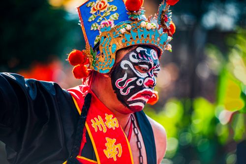 Free Vibrant Taiwanese performer in traditional costume with colorful face paint at a cultural festival. Stock Photo