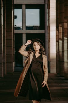 Fashionable woman in a stylish outfit poses confidently outside an architectural backdrop, exuding elegance.