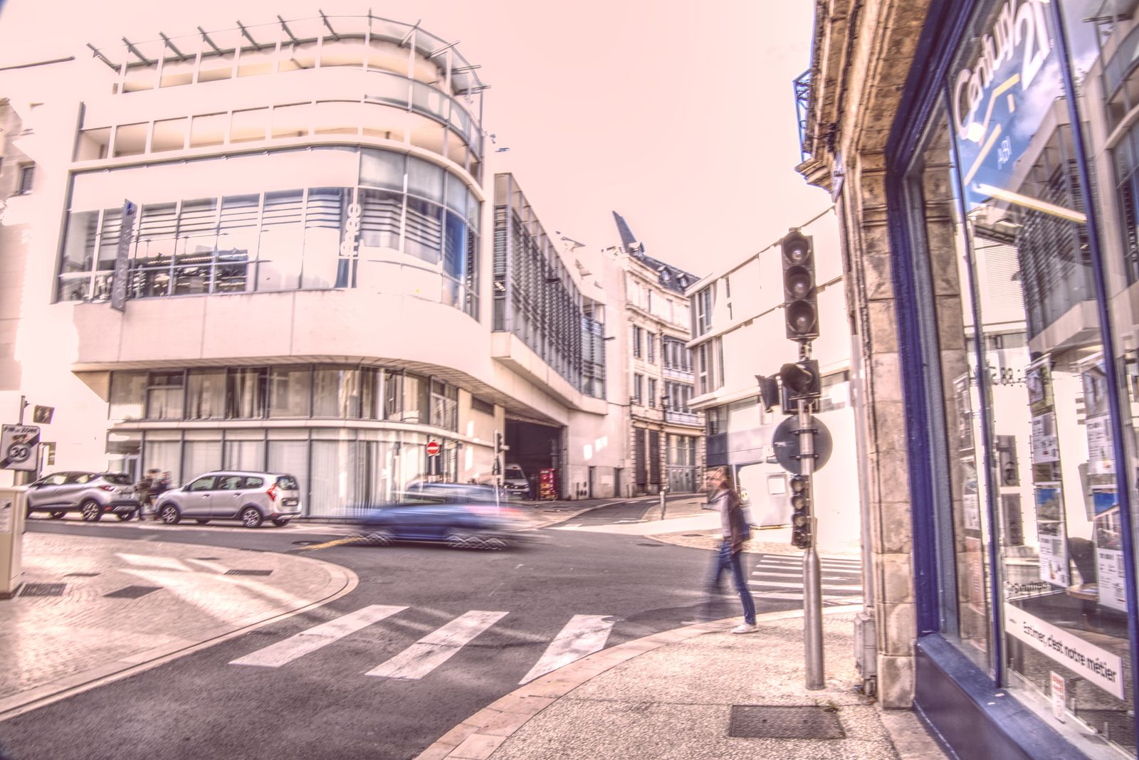 Piéton traversant un carrefour devant un immeuble moderne arrondi