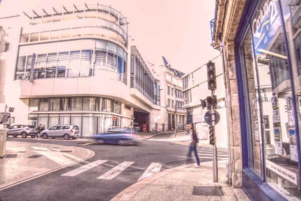 Piéton traversant un carrefour devant un immeuble moderne arrondi