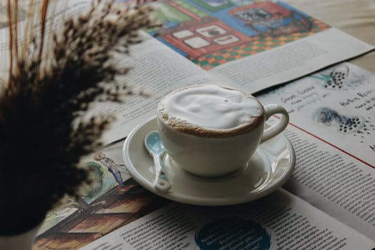 A tranquil scene of cappuccino with a newspaper, perfect for a relaxing morning.