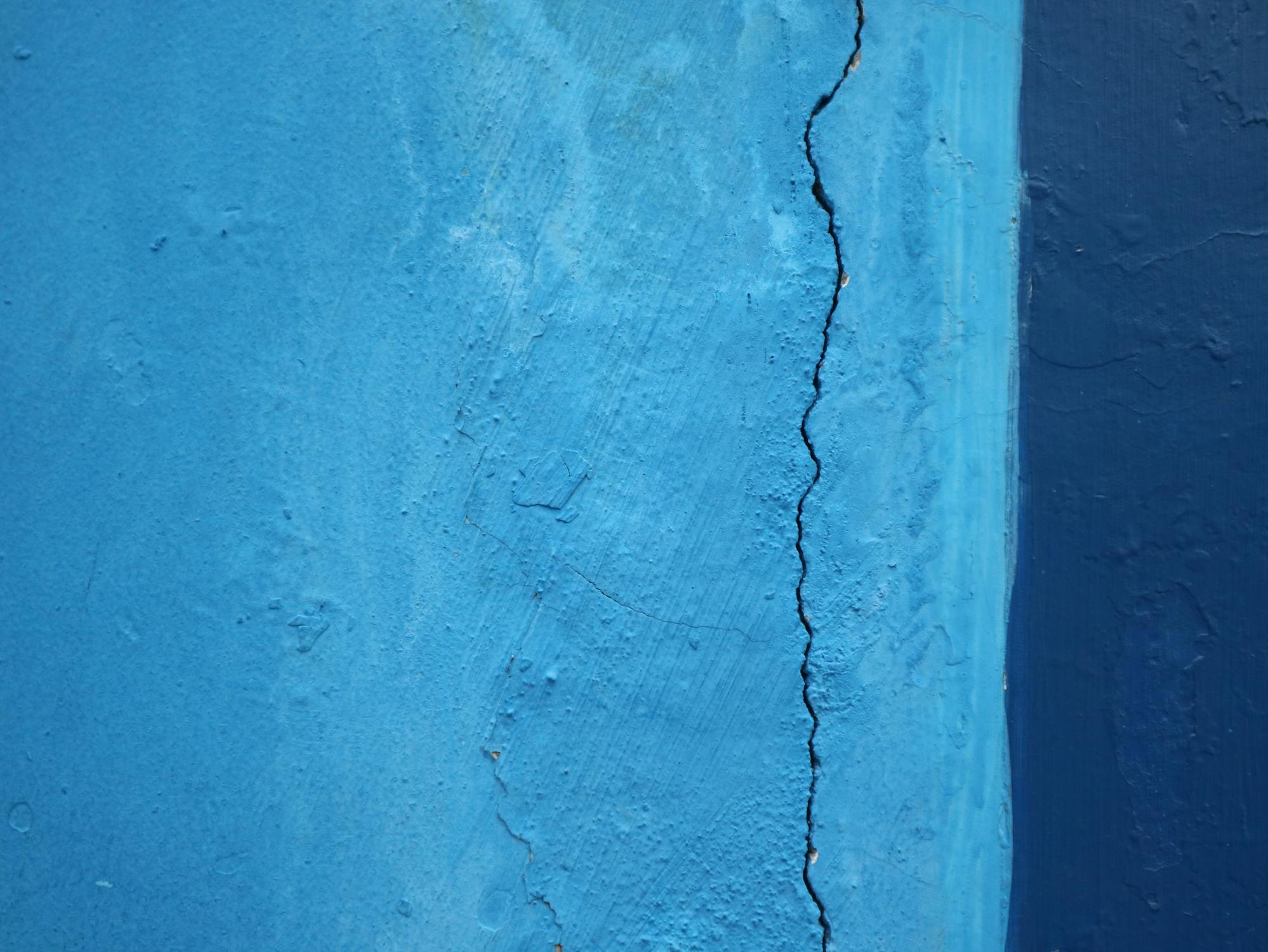 Muro azzurro con una lunga crepa sulla destra