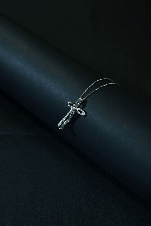 Free Close-up of a luxurious diamond cross pendant necklace on a black backdrop, exuding sophistication. Stock Photo
