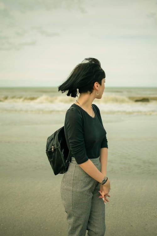 A Woman in Black Shirt Standing on the Beach