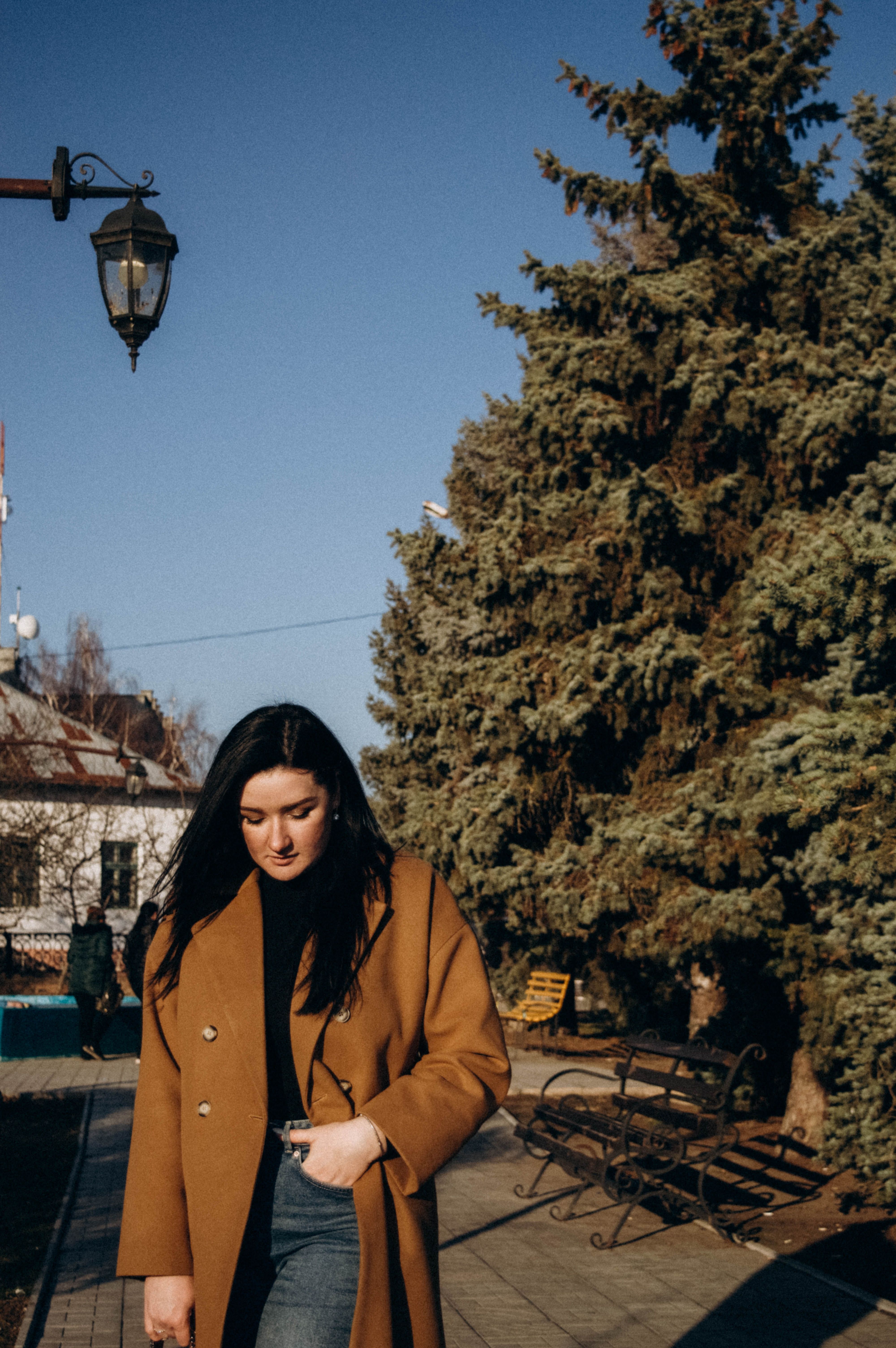 Woman in Brown Coat Standing Near a Bench · Free Stock Photo