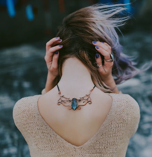 Vrouw Draagt Een Goudkleurige Ketting Met Hanger Van Blauwe Edelsteen