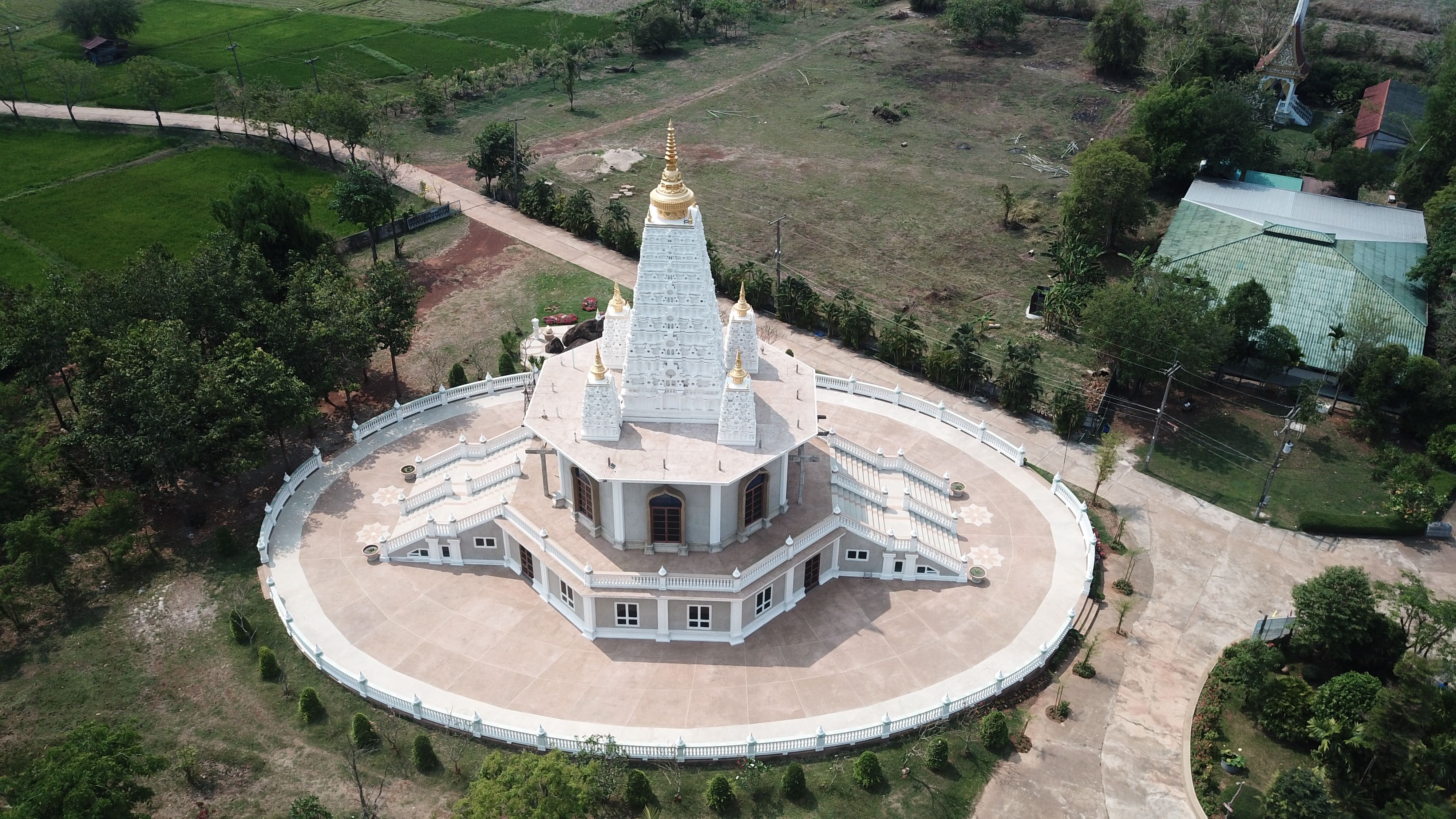 Aerial view of a shrine in Na Tong Watthana, Thailand with lush surroundings.