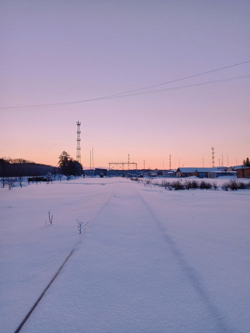 Free A tranquil winter scene of a snow-covered railway under the serene sunset sky in Berdsk, Russia. Stock Photo