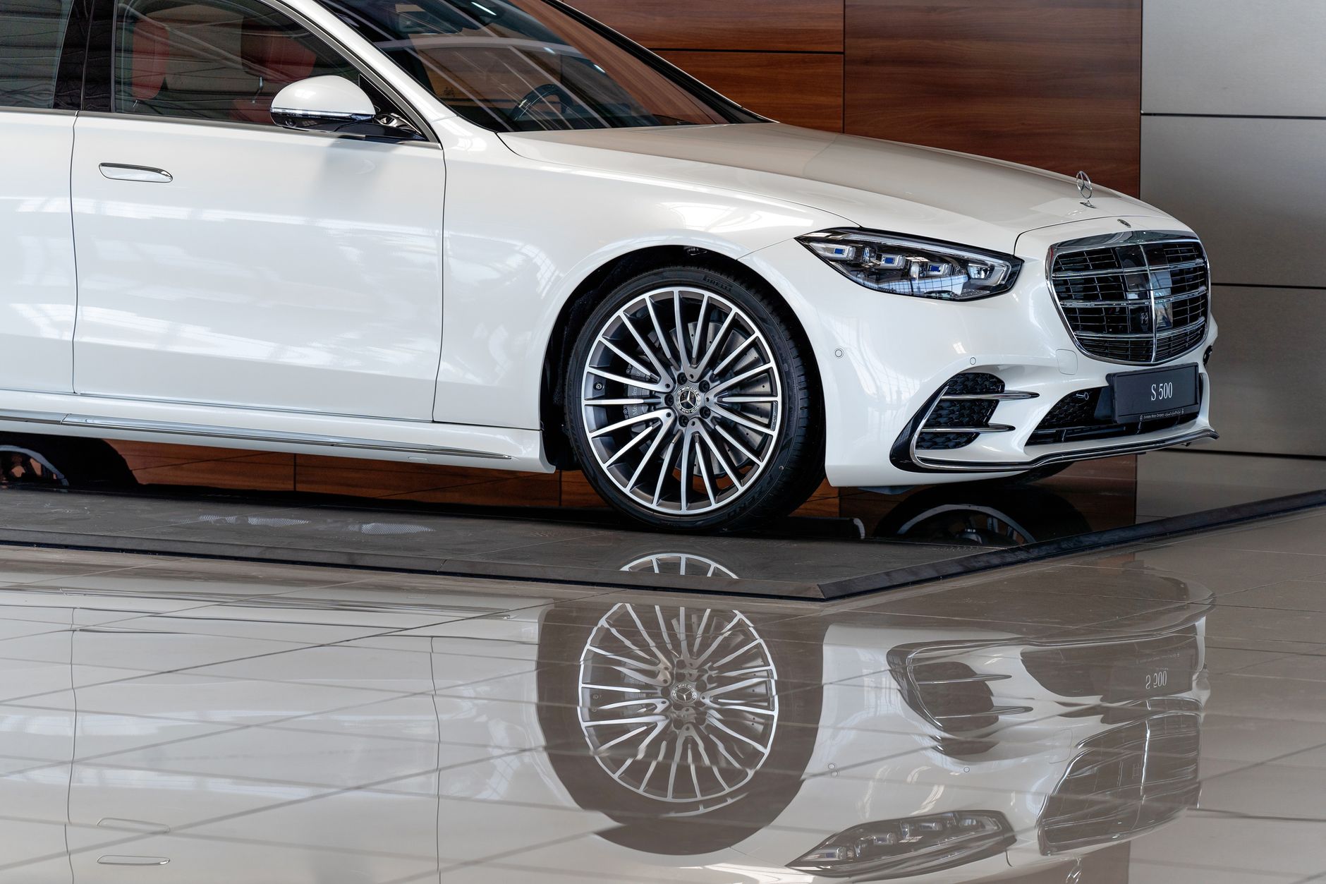 Luxurious white sedan showcased elegantly in a Dubai car showroom, featuring an impressive design and style.