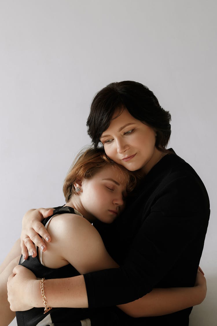 Mother And And Her Daughter Hugging Each Other On White Background