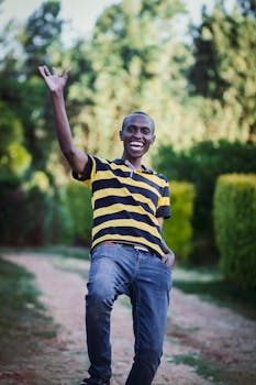 一个开朗的男人在阳光明媚的户外，脸上洋溢着灿烂的笑容，表达着喜悦和幸福