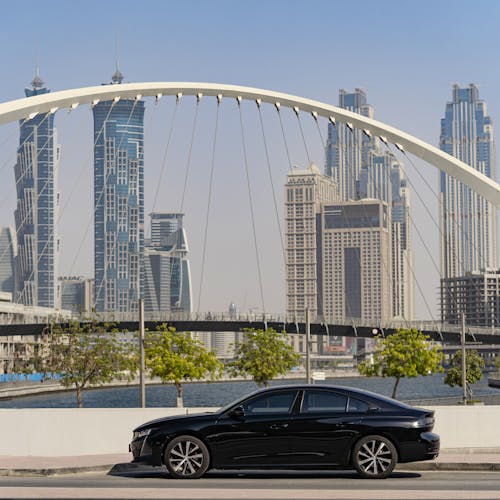 Free Black Car against Dubai Downtown Stock Photo