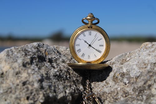 A Gold Pocket Watch on Gray Rock