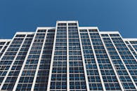 低角度视角下的现代摩天大楼，反光窗户映衬着清澈的蓝天