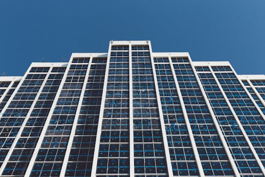 低角度视角下的现代摩天大楼，反光窗户映衬着清澈的蓝天