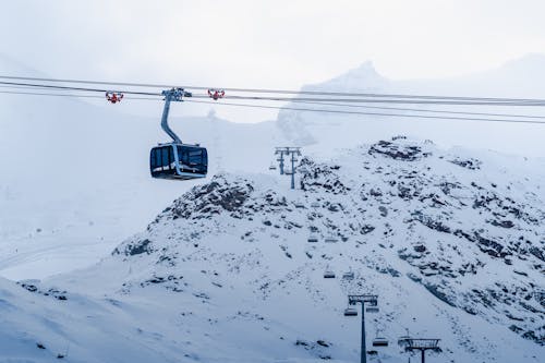 A Ski Lift Passing Over Snow Covered Mountain