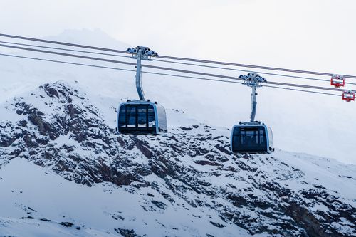 Free Cable cars in Zermatt, Switzerland, suspended over snowy alpine landscape in winter. Stock Photo