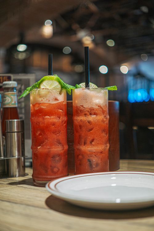 Free Two refreshing tomato juice cocktails with lime and celery garnish served in a restaurant setting. Stock Photo