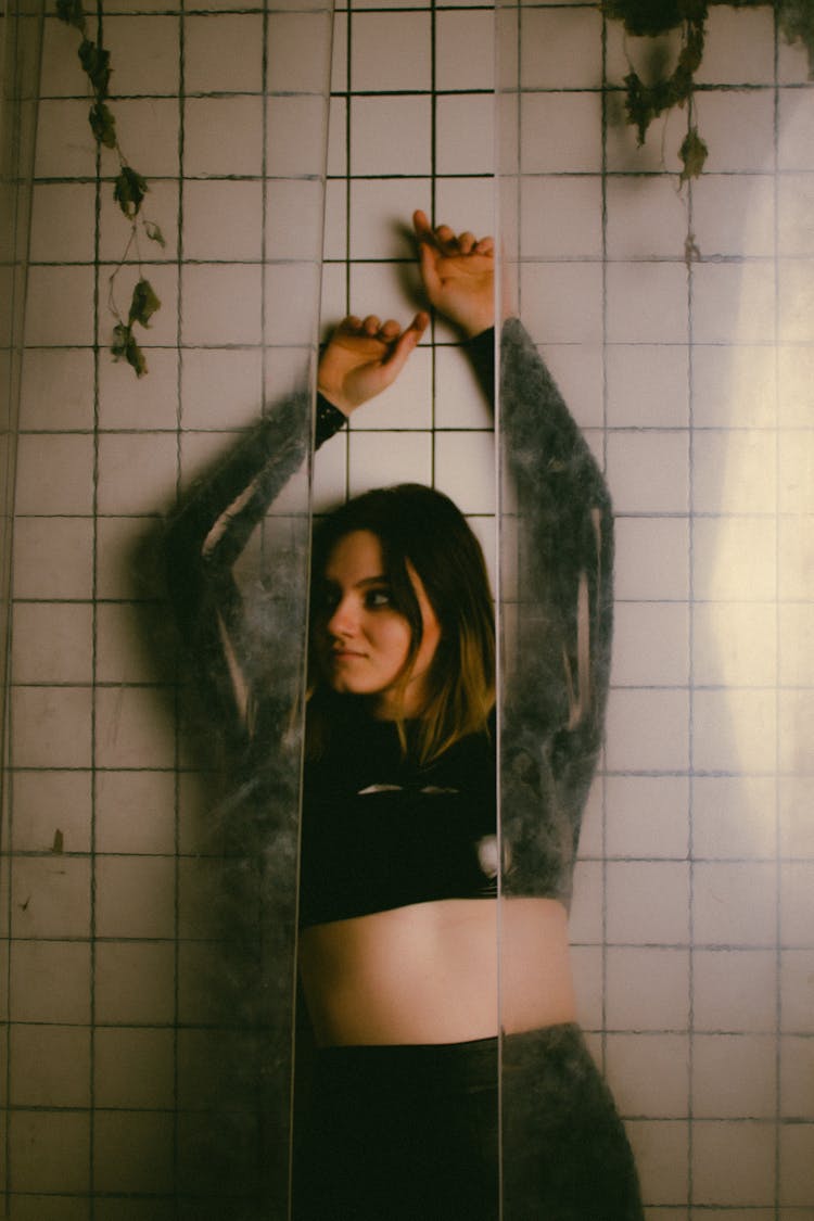 Young Woman Standing Against A Wall In A Bathroom 