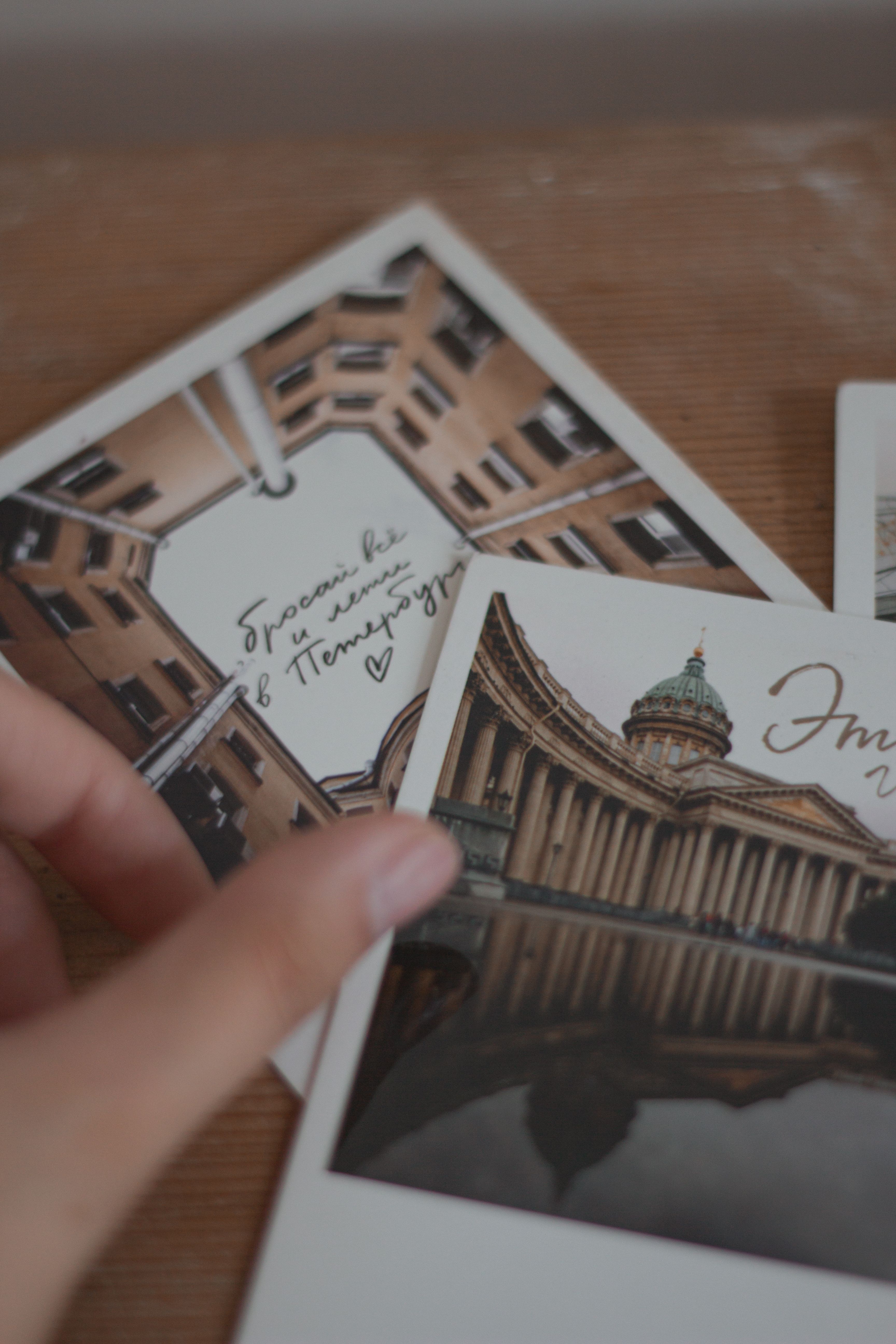 Stylish architectural postcards displayed on a textured wooden table.