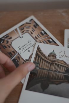 Stylish architectural postcards displayed on a textured wooden table.
