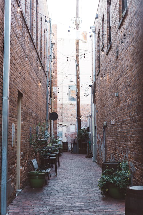 бесплатная Уличная аллея между домами из коричневого кирпича Стоковое фото