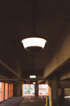 一个现代城市停车场内部，顶部装有照明灯