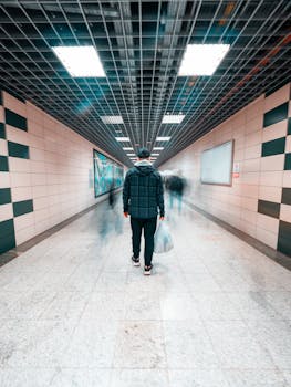 A person walking through a modern underground hallway with a concept of motion and solitude.