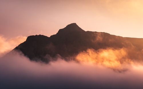 Free Captivating view of a mountain peak in Iceland enveloped by clouds at sunset. Stock Photo