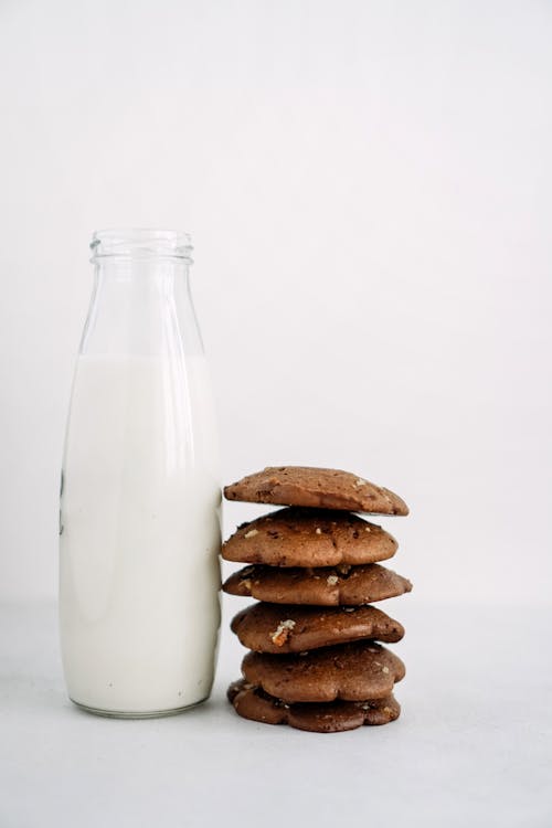 Stacked Cookies Beside a Bottle of Milk