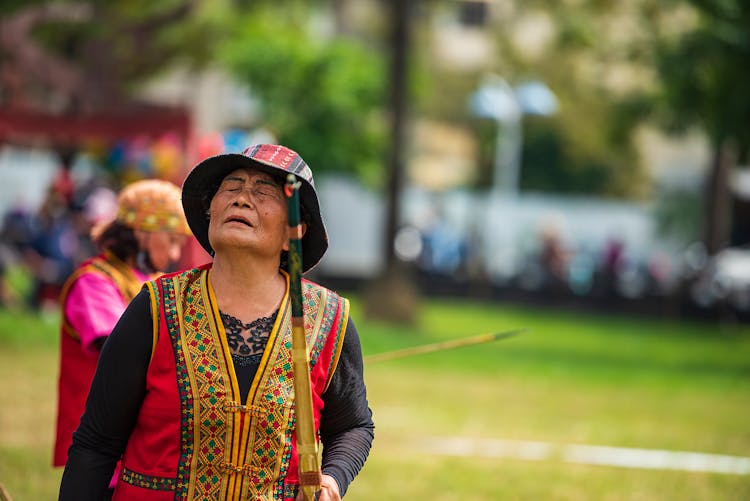 Woman Wearing Bucket Hat Holding A Broom 