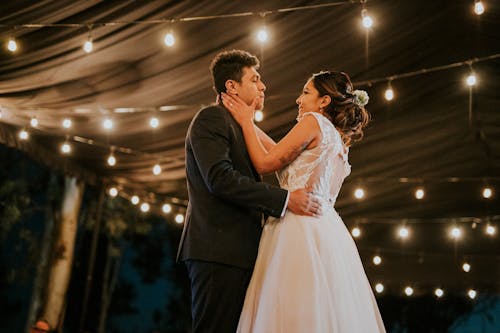 A Bride and Groom Dancing Under Light Strings