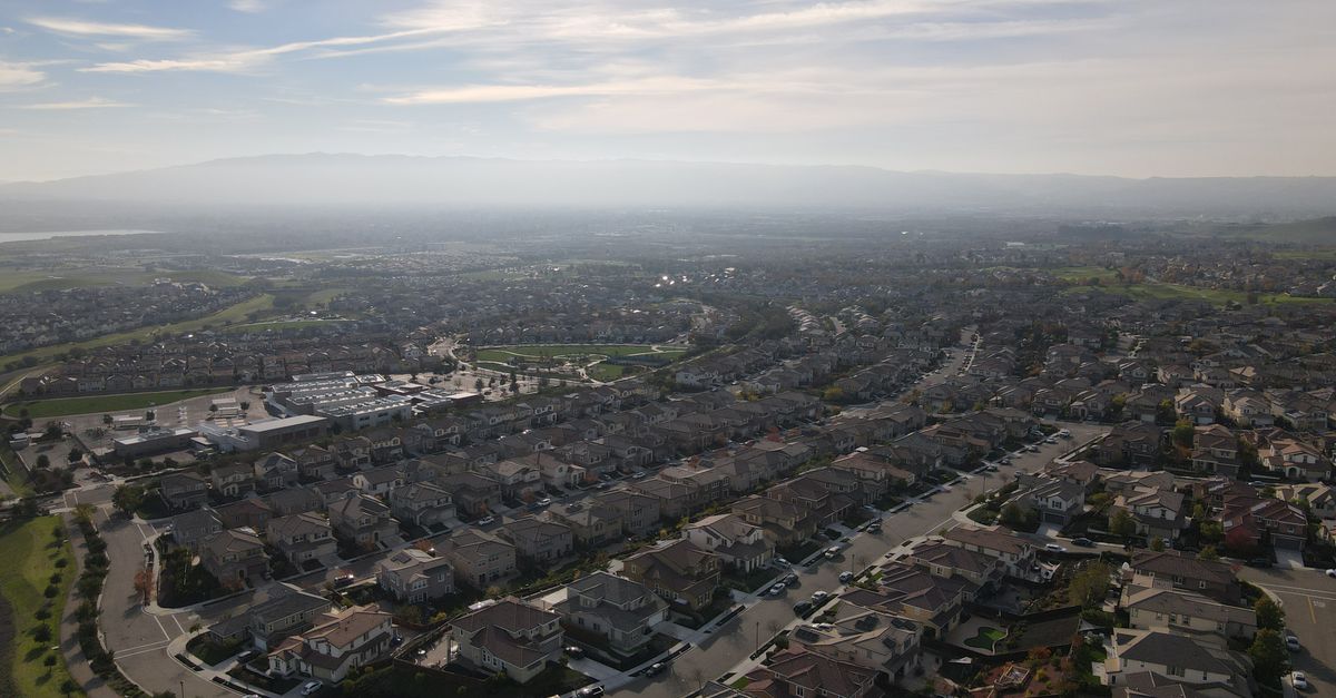 Bird's eye view of a suburban residential area in Dublin, CA with a clear sky and distant hills.