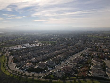 Bird's eye view of a suburban residential area in Dublin, CA with a clear sky and distant hills.