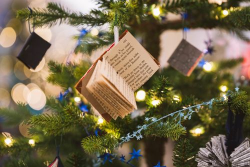 Free A decorated Christmas tree featuring a book-themed ornament, perfect for holiday cheer. Stock Photo
