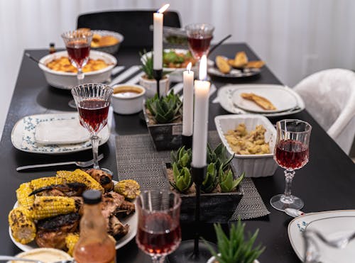 Free Stylish Table Setting with Cooked Food and Crystal Glasses Stock Photo