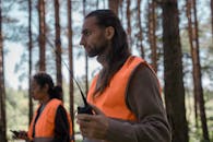 People in Jacket Uniform Holding a Radio