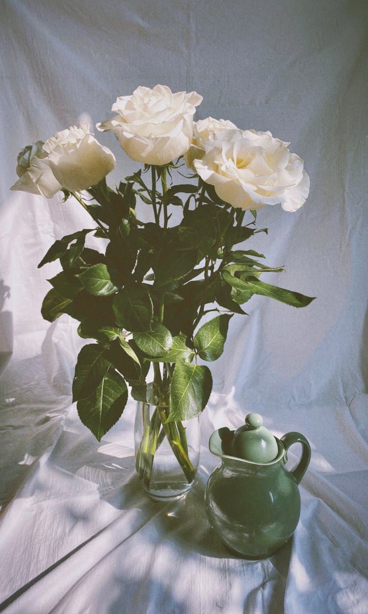 Bunch Of White Roses In Glass Vase And Green Jug