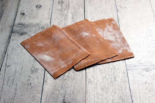 Brown Leather Sheets on the Wooden Surface