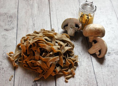 Mushrooms and Pasta on the Wooden Table