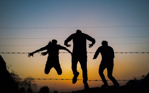 Free Three Person Silhouette Photo during Golden Hour Stock Photo