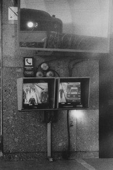 Black and white photo of surveillance screens displaying urban scenes, with a retro vibe.