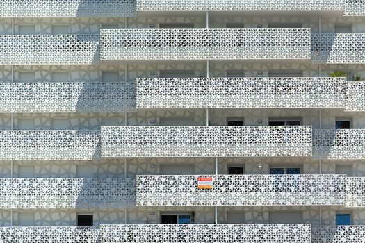Close-up of a contemporary building facade with a geometric pattern and shadows.
