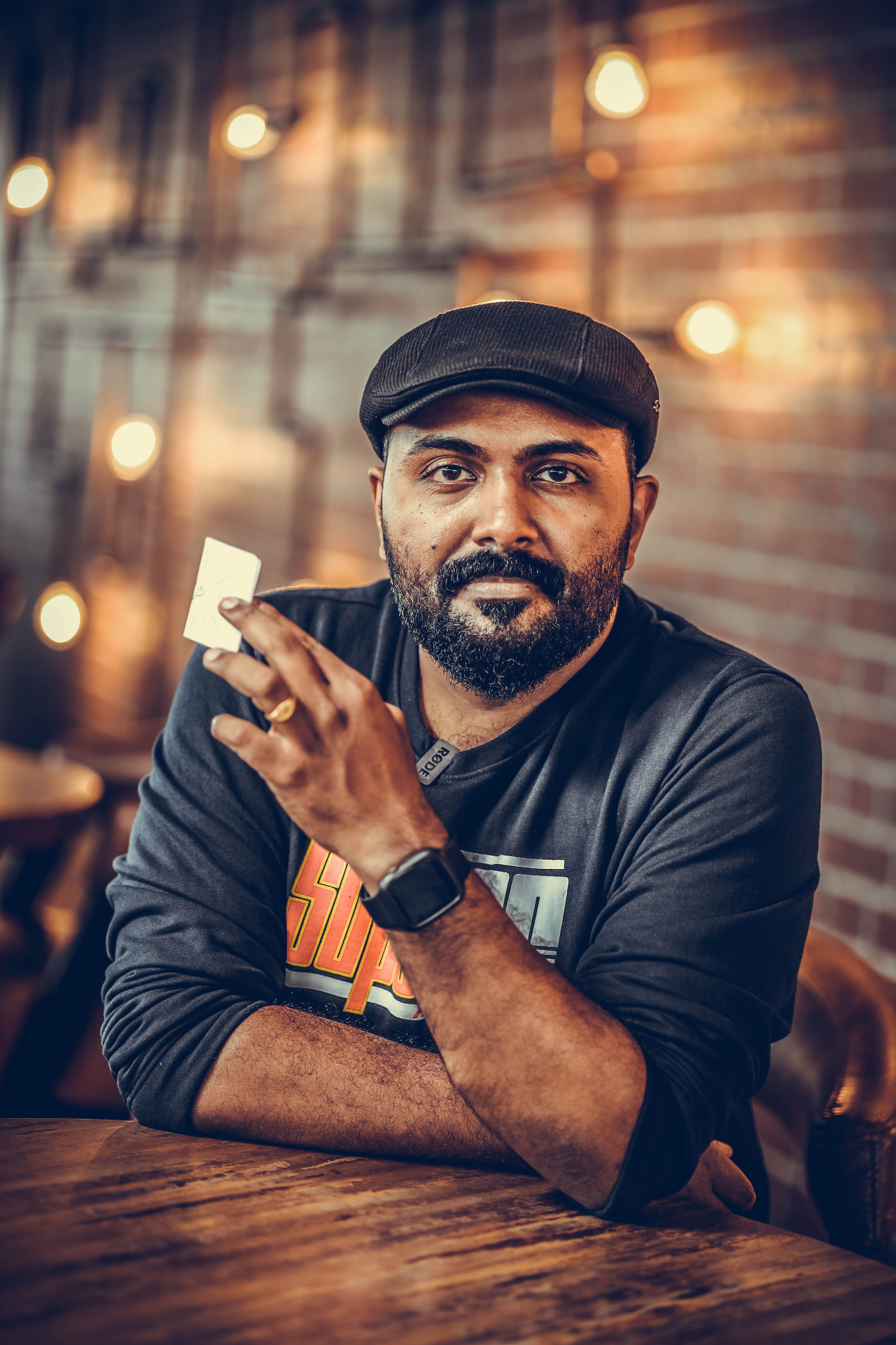 Casual portrait of a bearded man in a relaxed setting with a warm backdrop