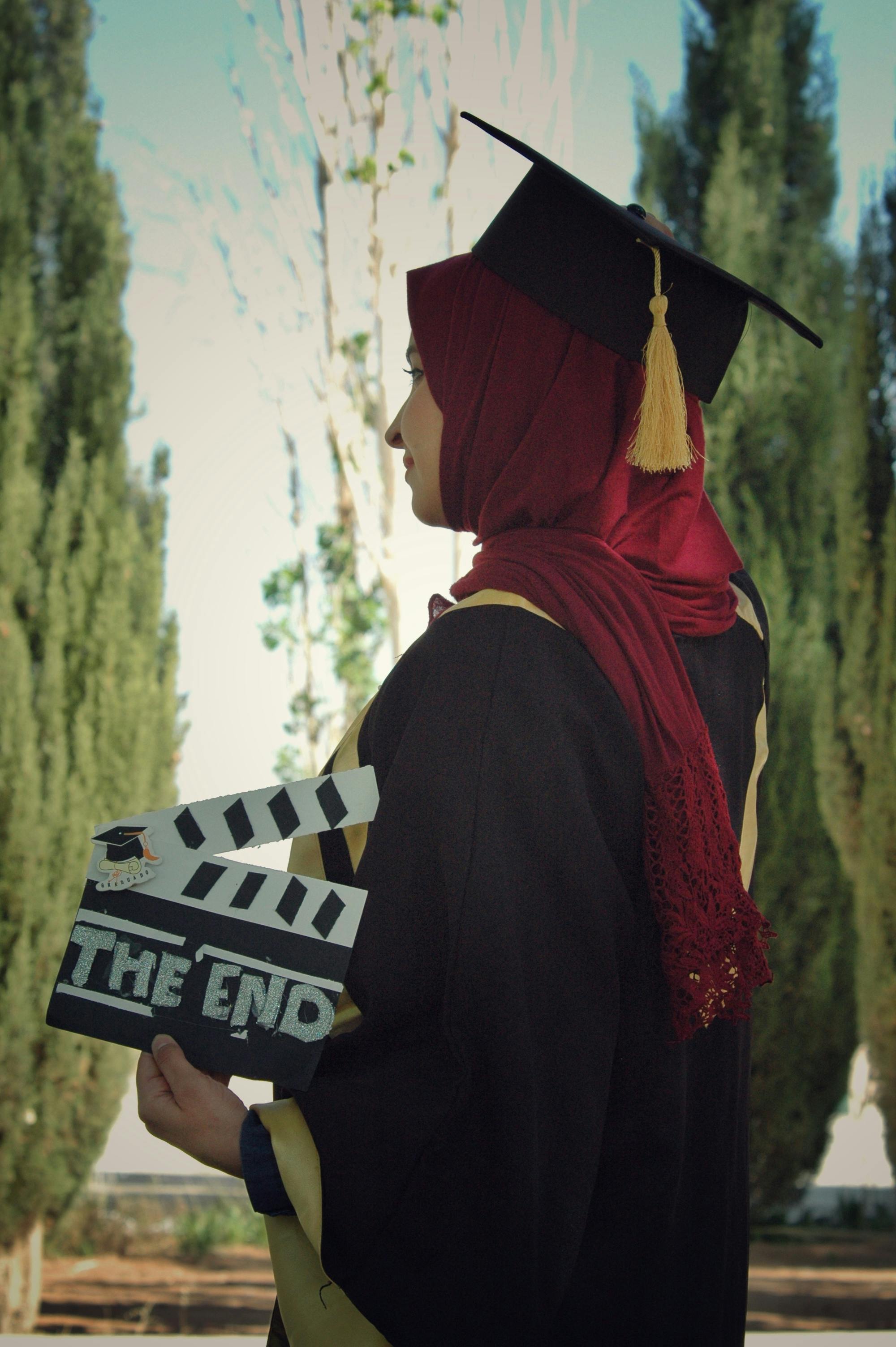 woman wearing academic dress while holding clipperboard