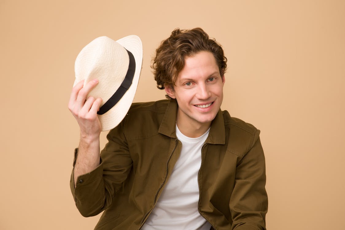 Free Man Wearing Brown Dress Shirt Holding White Fedora Hat Stock Photo
