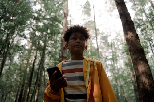 Teenage Boy in Yellow Raincoat with Head in Hands in Forest · Free ...