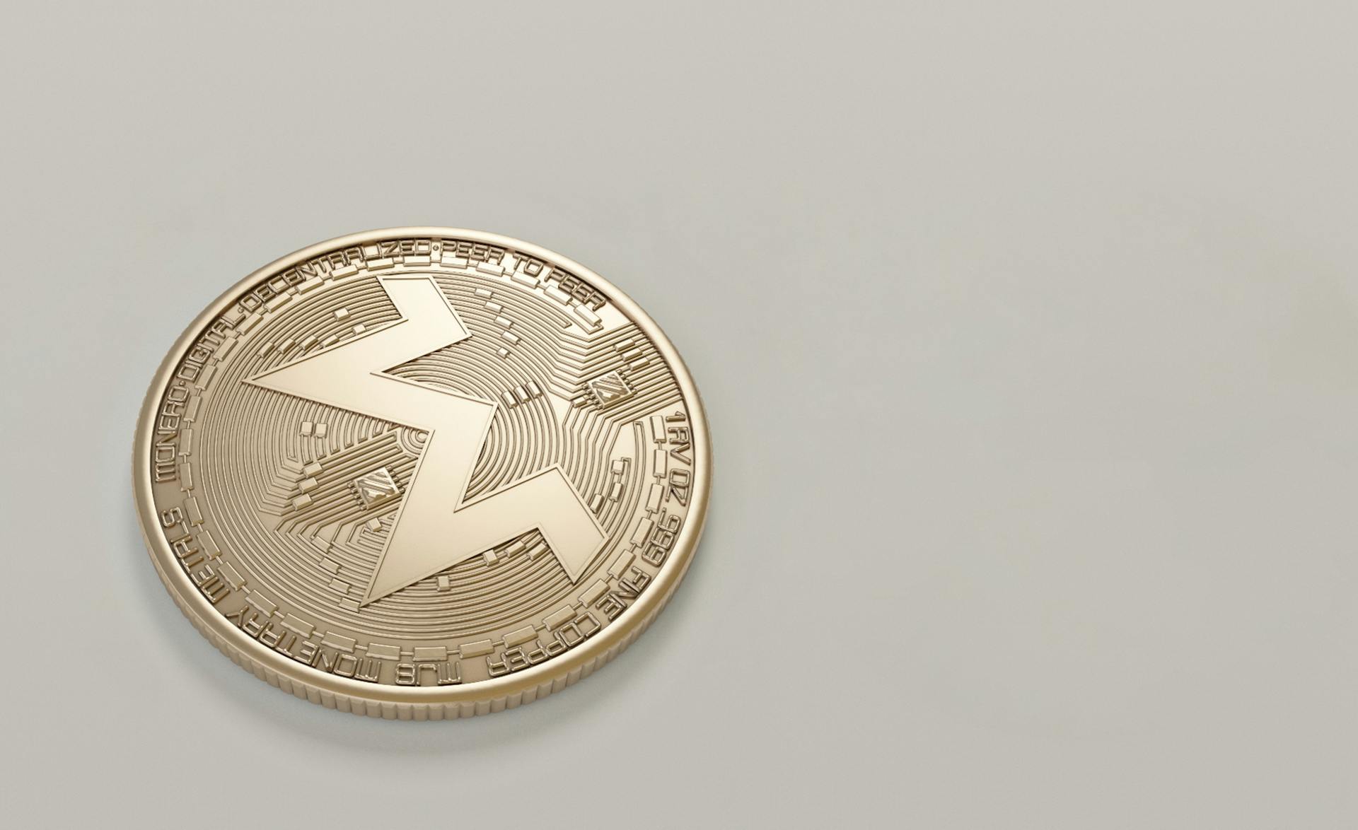 High-quality image of a Monero cryptocurrency coin on a minimalistic light background.