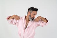 一个轻松自信的男人穿着舒适的粉红色长袍，摆出休闲的肖像姿势