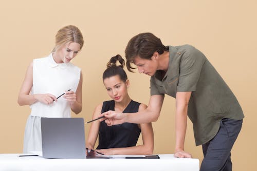 Two Woman and One Man Looking at the Laptop